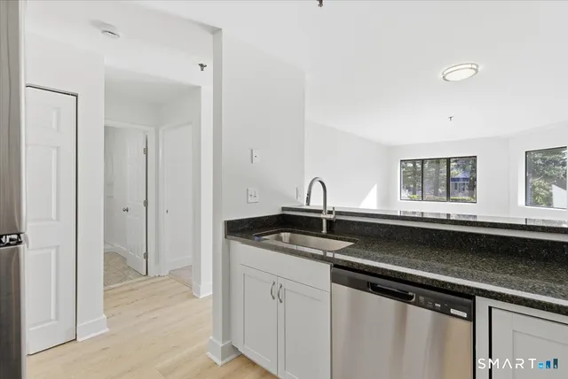 a kitchen with granite countertop a sink and cabinets