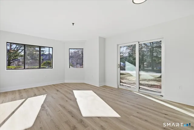 a bedroom with wooden floor and windows