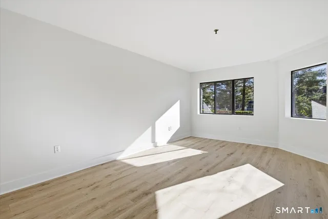 a view of a big room with wooden floor and windows
