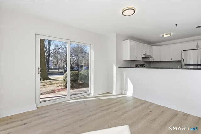a kitchen with granite countertop a refrigerator and wooden floor