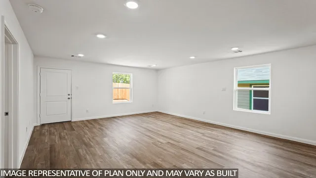an empty room with wooden floor and window