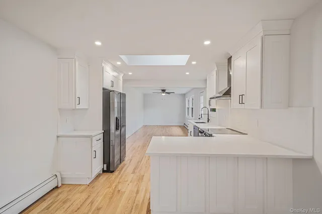 a kitchen with white cabinets and refrigerator