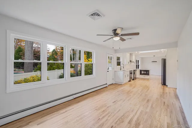 a view of a room with wooden floor and white walls