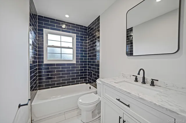 a bathroom with a toilet sink vanity and mirror