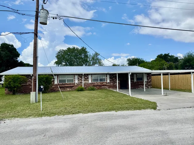 a view of a house with a backyard