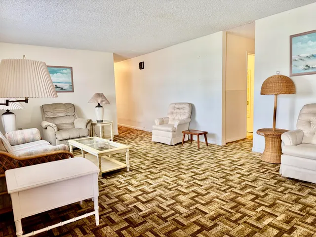 a living room with a couch and chandelier next to a window
