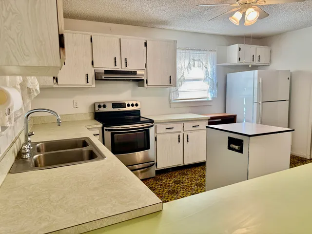 a kitchen with sink a stove and cabinets