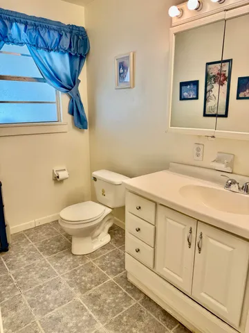 a bathroom with a toilet sink and mirror