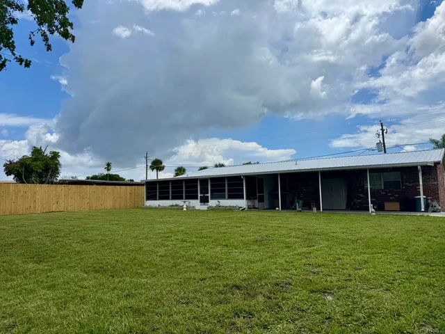 a view of a house with a yard and sitting area