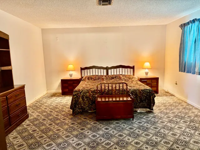 a bed sitting in a bedroom next to a window