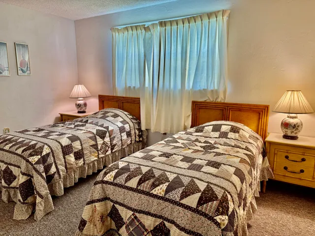 a bedroom with two beds and lamp