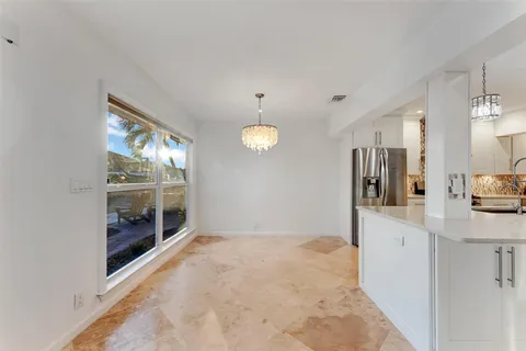 a large white kitchen with granite countertop a sink and cabinets