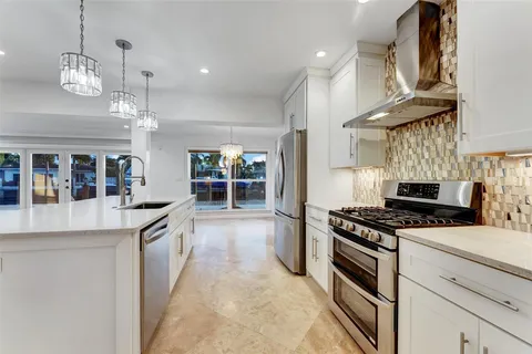 a large kitchen with stainless steel appliances a large center island attached withe living room