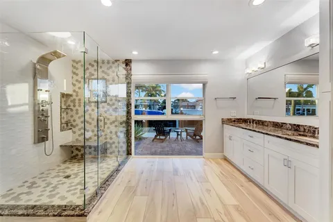a bathroom with a granite countertop double vanity sink and mirror