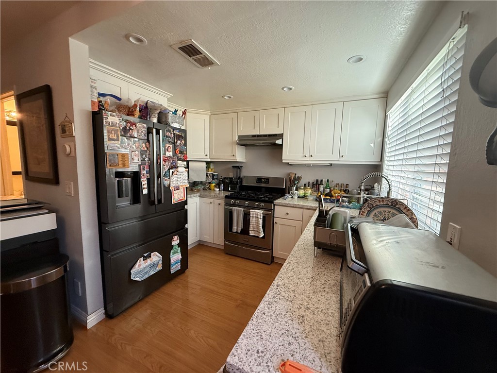 9565 Graham Street Cypress, CA 90630 - Photo 20 of 29 a kitchen with stainless steel appliances granite countertop a refrigerator a stove top oven a sink and dishwasher