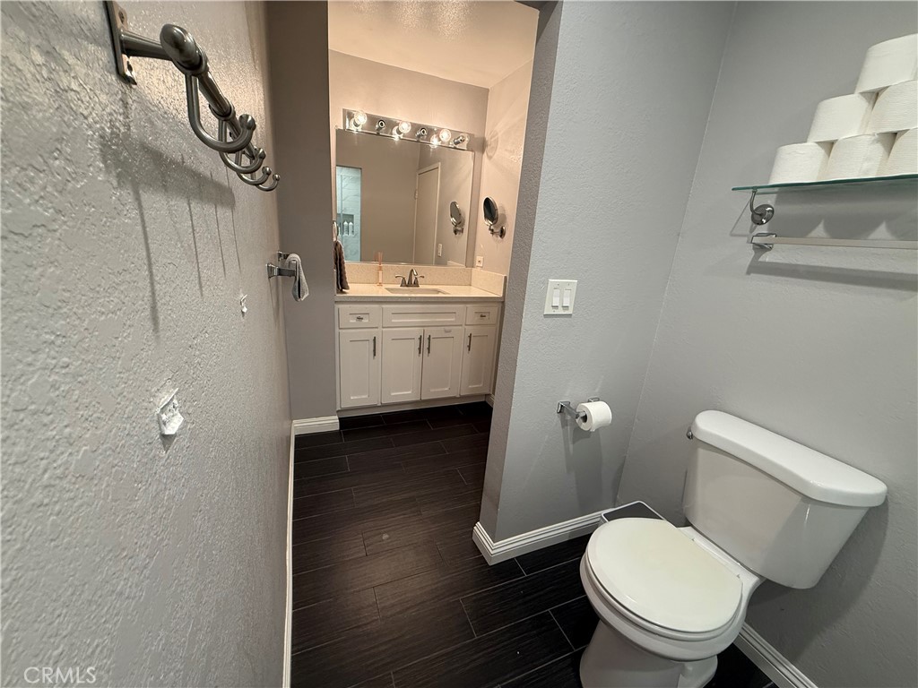 9565 Graham Street Cypress, CA 90630 - Photo 6 of 29 a bathroom with a toilet a sink and mirror
