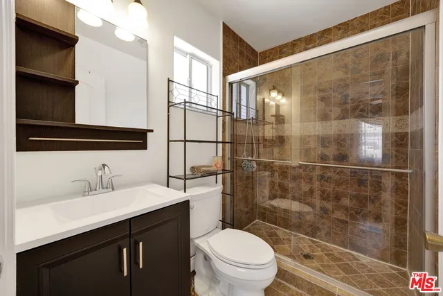 a bathroom with a sink a toilet and shower