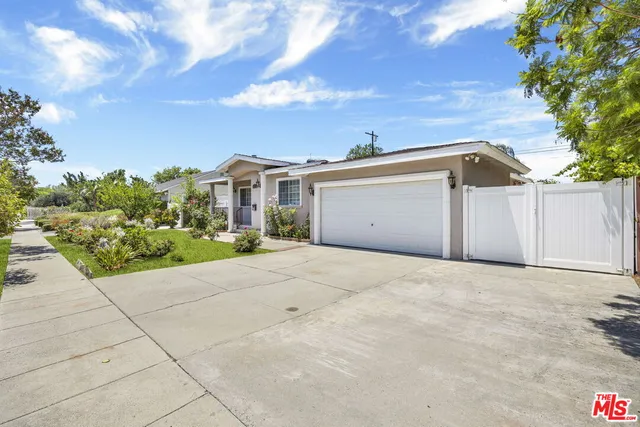 a view of a house with a yard and potted plants