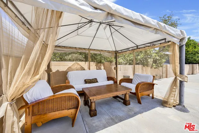 a outdoor living space with furniture and umbrella