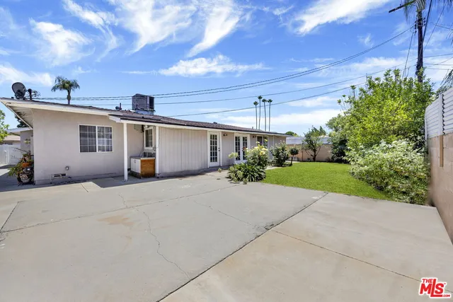 a view of a house with a yard and potted plants