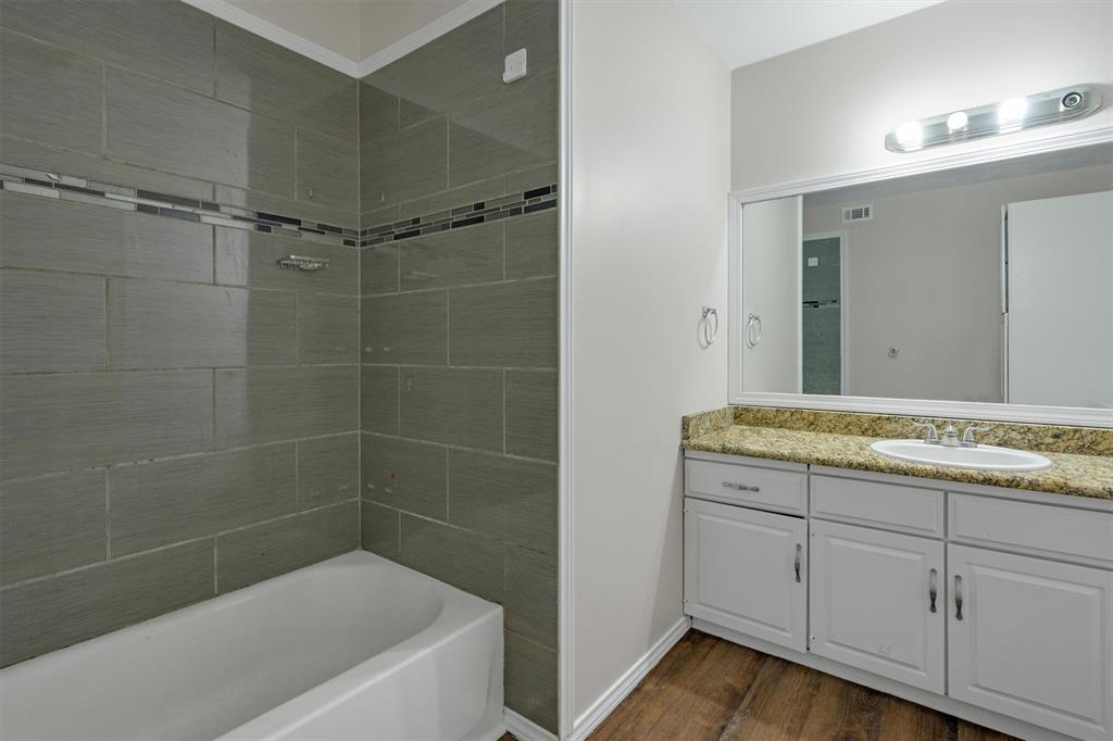 209 Mistletoe Lane Keene, TX 76059 - Photo 35 of 38 a bathroom with a granite countertop sink a toilet and bathtub