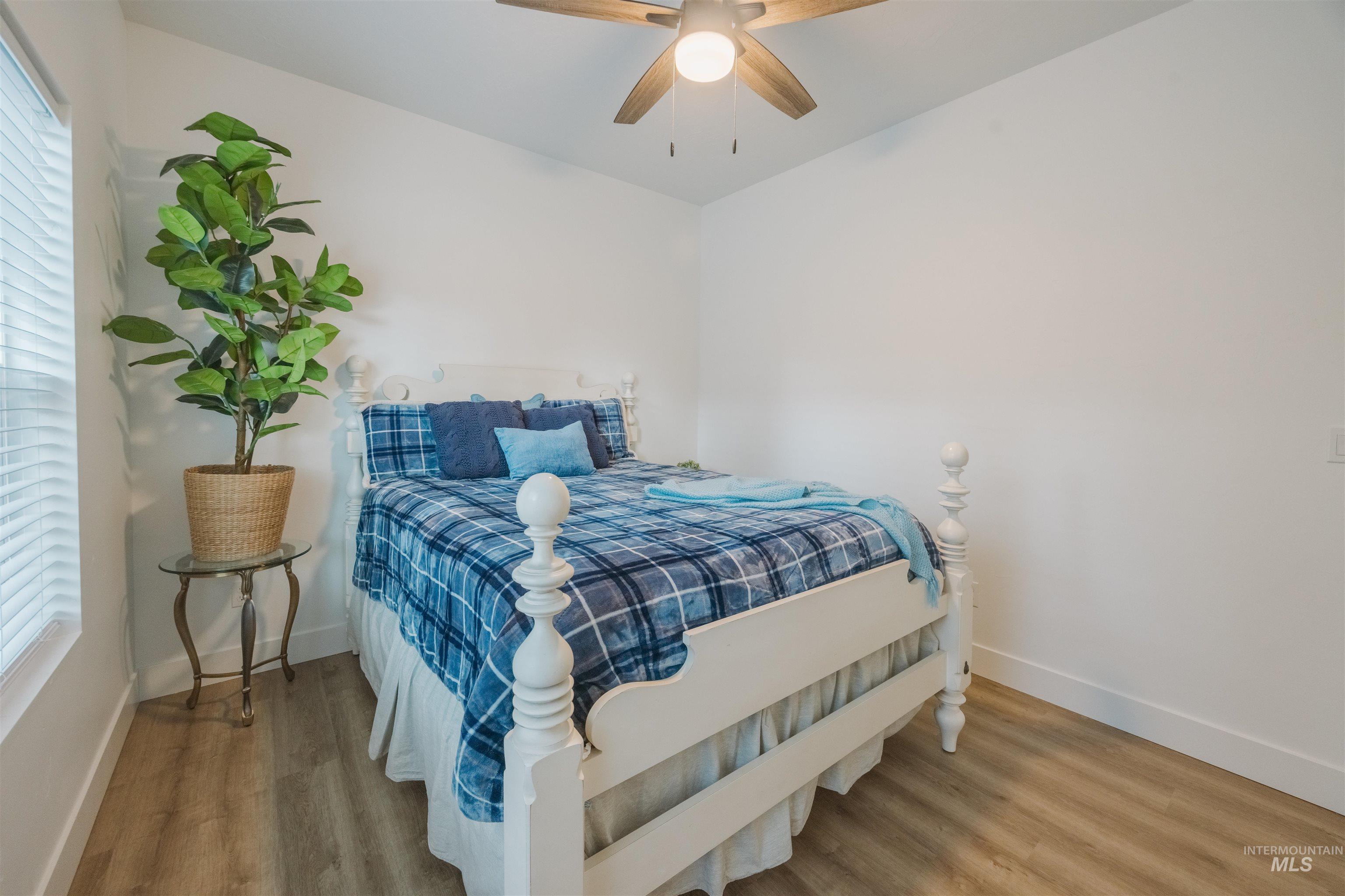 3873 Hot Springs Road New Meadows, ID 83654 - Photo 9 of 25 Bedroom featuring wood-finish flooring, white baseboards, and a ceiling fan with integrated lighting