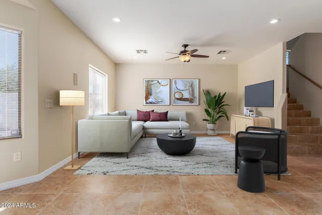 a living room with furniture a chandelier and a flat screen tv