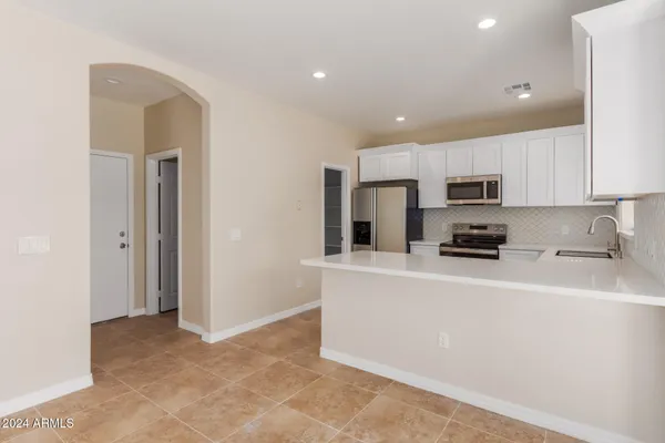 a kitchen with stainless steel appliances a refrigerator sink stove microwave and cabinets