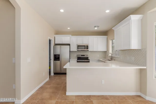 a kitchen with stainless steel appliances a refrigerator sink stove microwave and cabinets