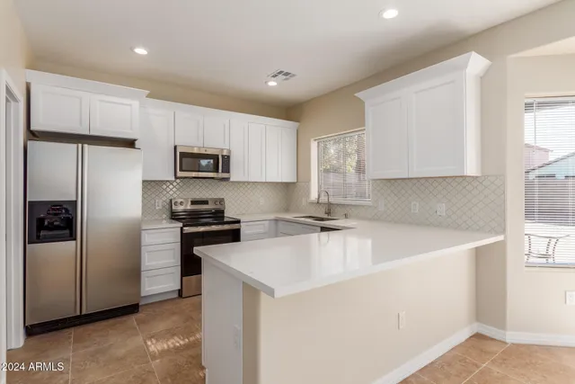 a kitchen with a refrigerator a microwave a sink and cabinets