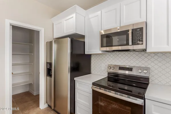 a kitchen with cabinets and steel stainless steel appliances