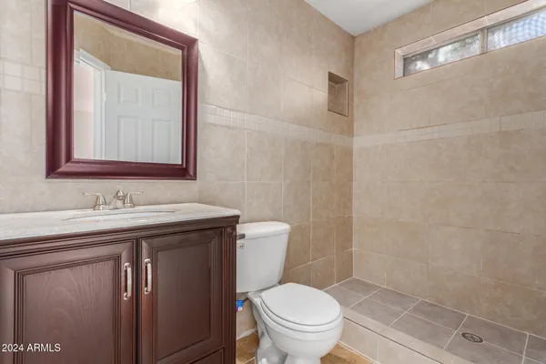 a bathroom with a toilet sink and mirror