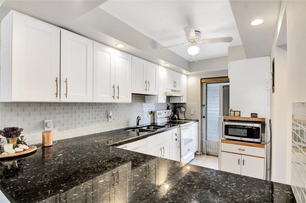 4500 North Federal Highway, Unit 158G Lighthouse Point, FL 33064 - Photo 1 of 36 a kitchen with granite countertop a sink a counter space appliances and cabinets