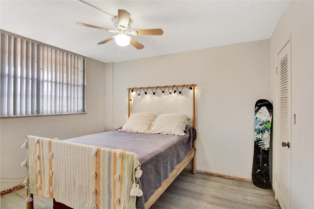 4500 North Federal Highway, Unit 158G Lighthouse Point, FL 33064 - Photo 12 of 36 a bedroom with a bed and a chandelier