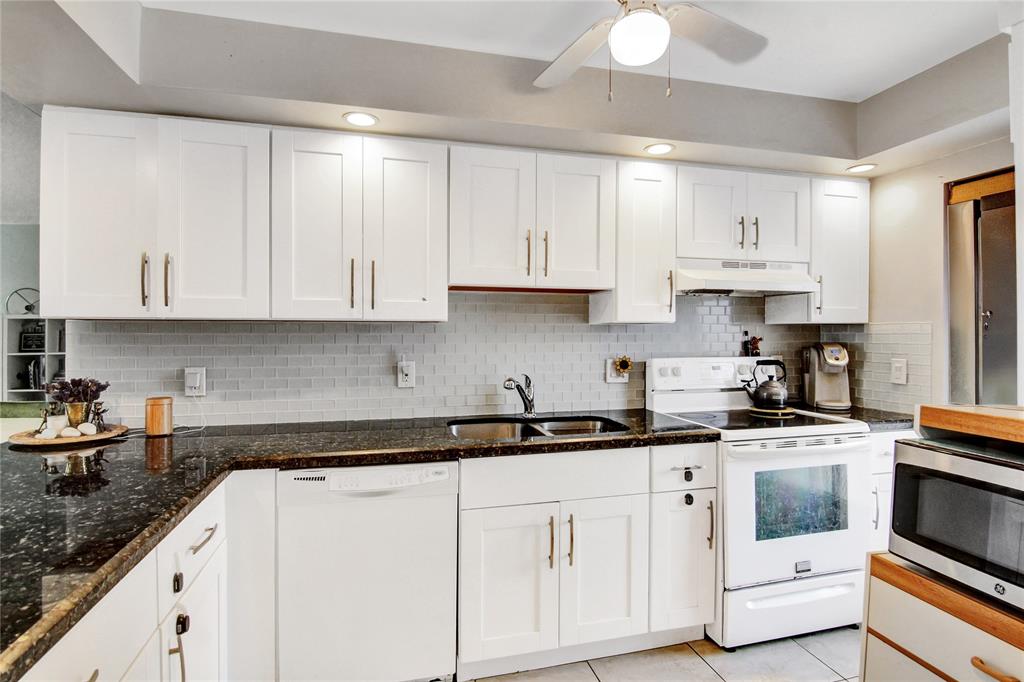 4500 North Federal Highway, Unit 158G Lighthouse Point, FL 33064 - Photo 2 of 36 a kitchen with white cabinets and white appliances