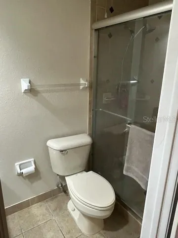 a white toilet sitting next to a shower