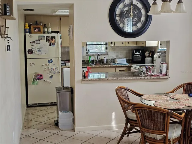 a kitchen with stainless steel appliances granite countertop a dining table and chairs