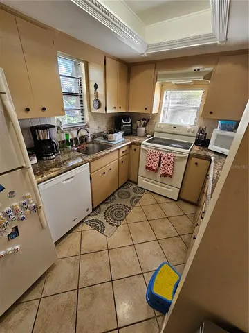 a kitchen with a sink a stove cabinets and a window