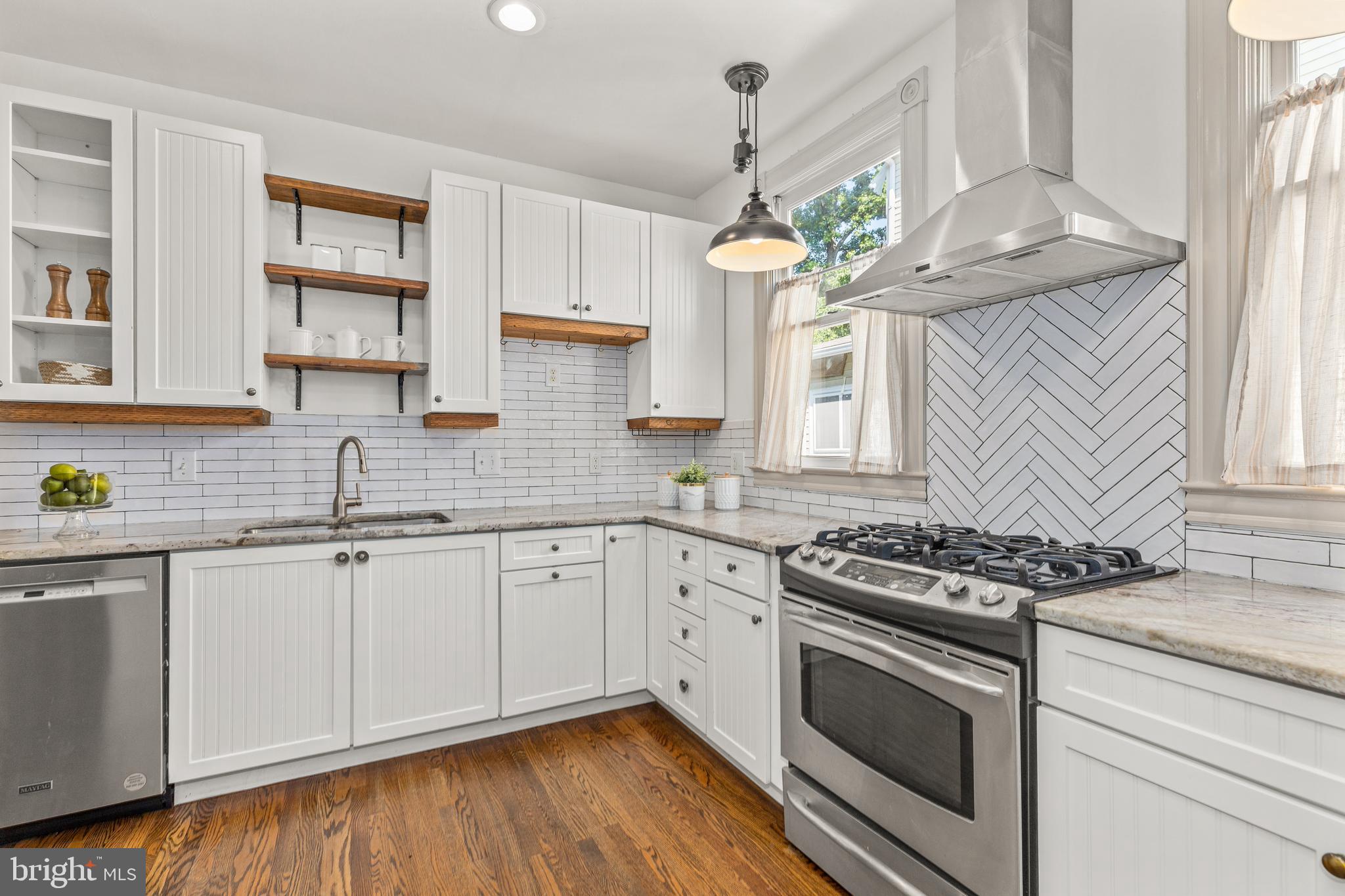 4916 40th Place Hyattsville, MD 20781 - Photo 17 of 48 a kitchen with stainless steel appliances granite countertop a sink a stove cabinets and wooden floor