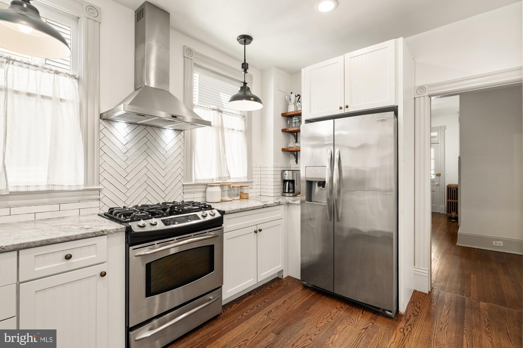 4916 40th Place Hyattsville, MD 20781 - Photo 18 of 48 a kitchen with stainless steel appliances a stove a refrigerator and a wooden floor
