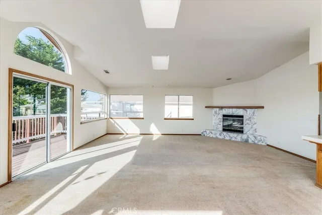a view of an empty room with a fireplace and a window