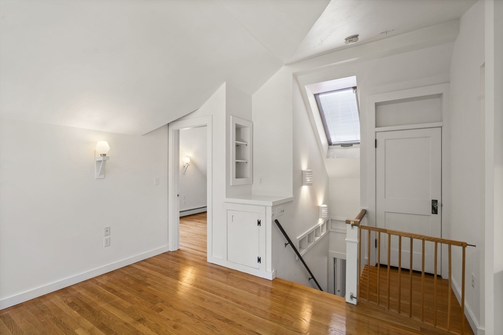 34 Westminster Road Newton, MA 02459 - Photo 16 of 40 a view of an empty room with wooden floor and a bathroom