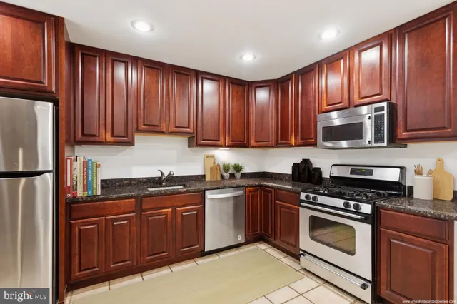 a kitchen with kitchen island wooden cabinets stainless steel appliances and a sink