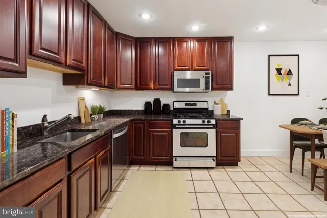 a kitchen with stainless steel appliances granite countertop a stove a sink dishwasher and a microwave oven on the blue kitchen countertops