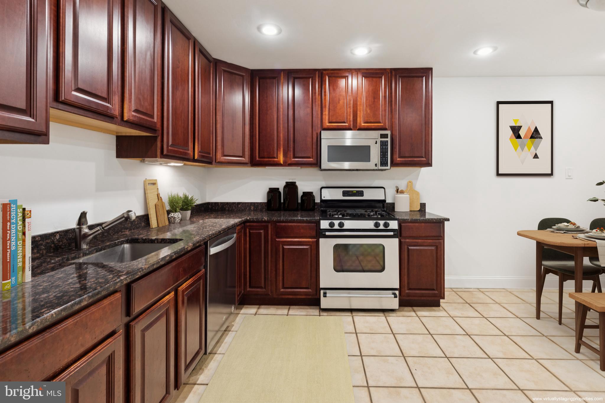 1232 South Street, Unit A Philadelphia, PA 19147 - Photo 15 of 27 a kitchen with stainless steel appliances granite countertop a stove a sink dishwasher and a microwave oven on the blue kitchen countertops