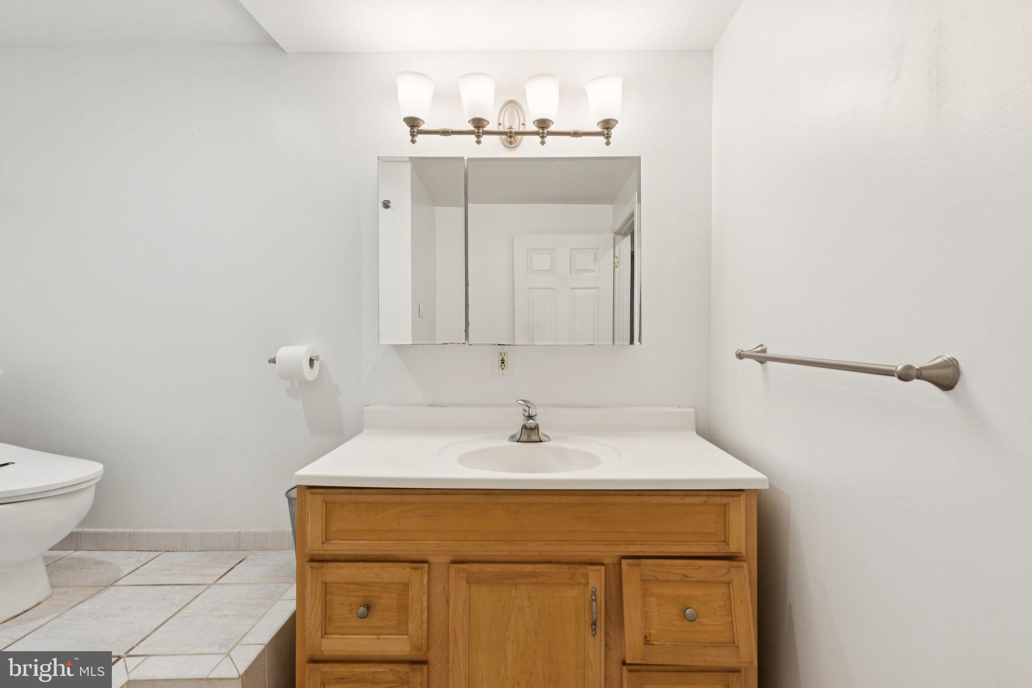 1232 South Street, Unit A Philadelphia, PA 19147 - Photo 21 of 27 a bathroom with a sink a toilet and mirror