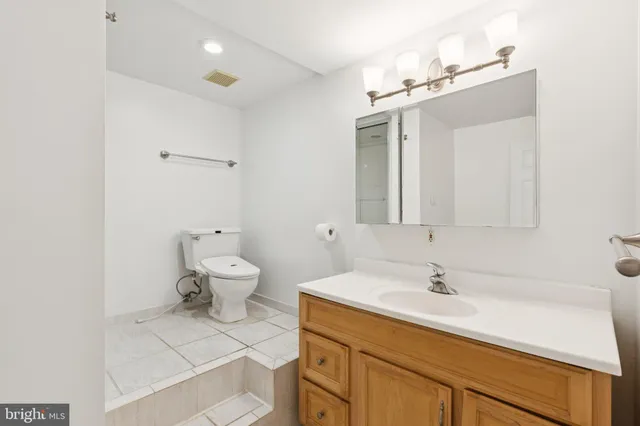 a bathroom with a sink a toilet and mirror