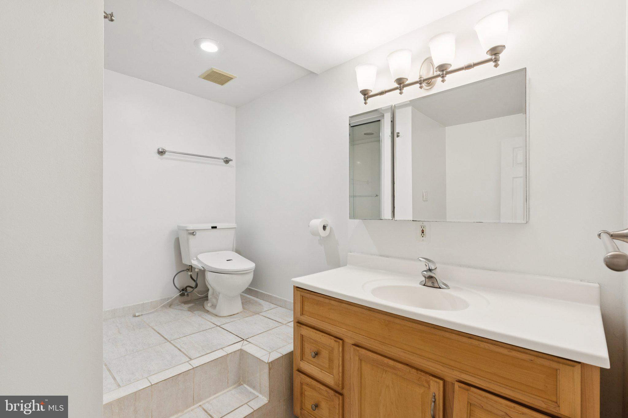 1232 South Street, Unit A Philadelphia, PA 19147 - Photo 22 of 27 a bathroom with a sink a toilet and mirror