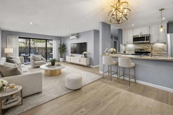 a living room with furniture a flat screen tv and kitchen view
