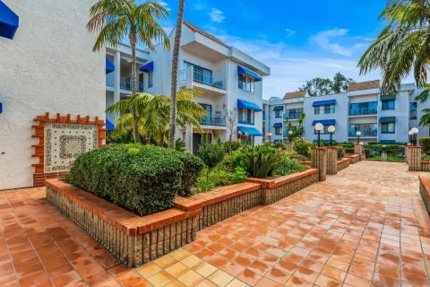 a view of a multi story residential apartment building with a yard and potted plants